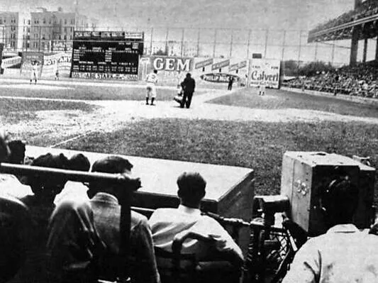 A close up photo of a large camera hanging over the Baseball dugout and recording a game.55