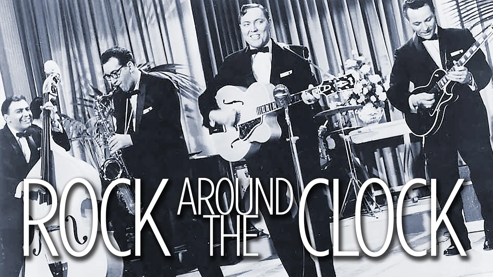 A photo of a live performance of Rock Around The Clock by Bill Haley and His Comets.