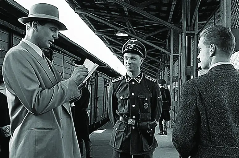 A still from Schindler's List of Schindler on the train platform of the concentration camp speaking with a SS guard.