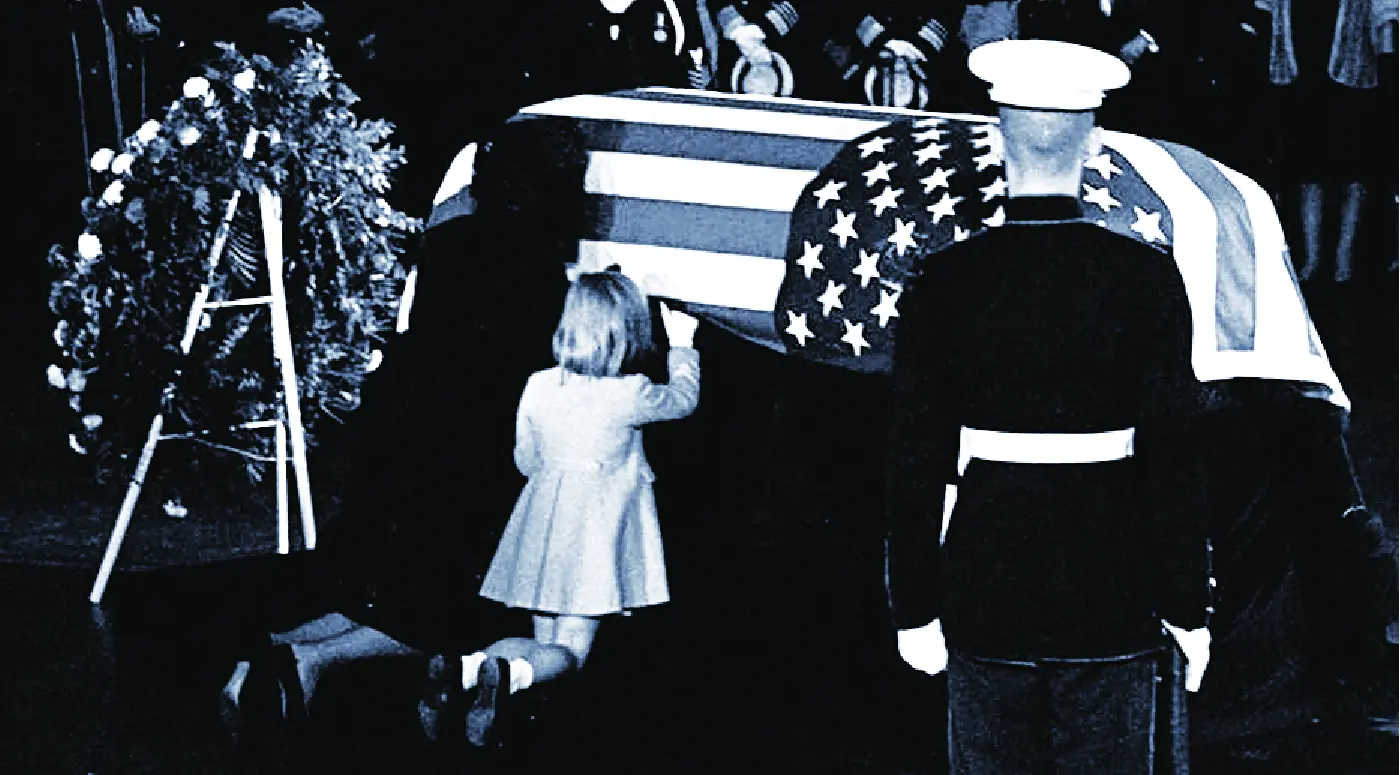 Jackie and Kennedy's daughter at JFK's coffin, with a marine standing guard.